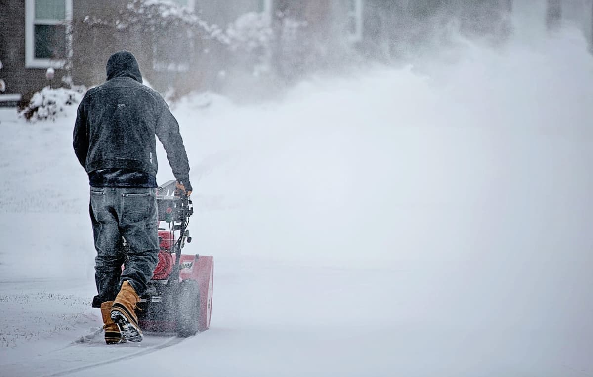 hvordan velge snøfreser: en mann bruker en snøfreser