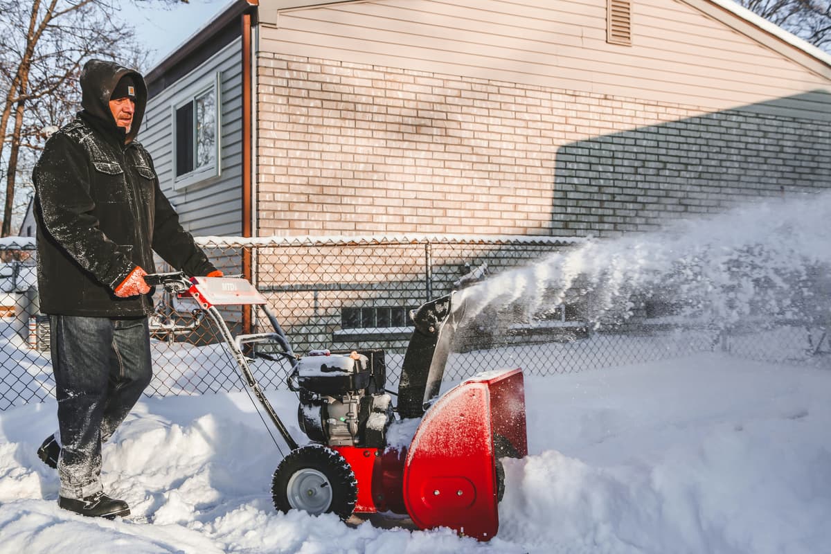 hvordan velge snøfreser: en mann rydder snø med en snøfreser