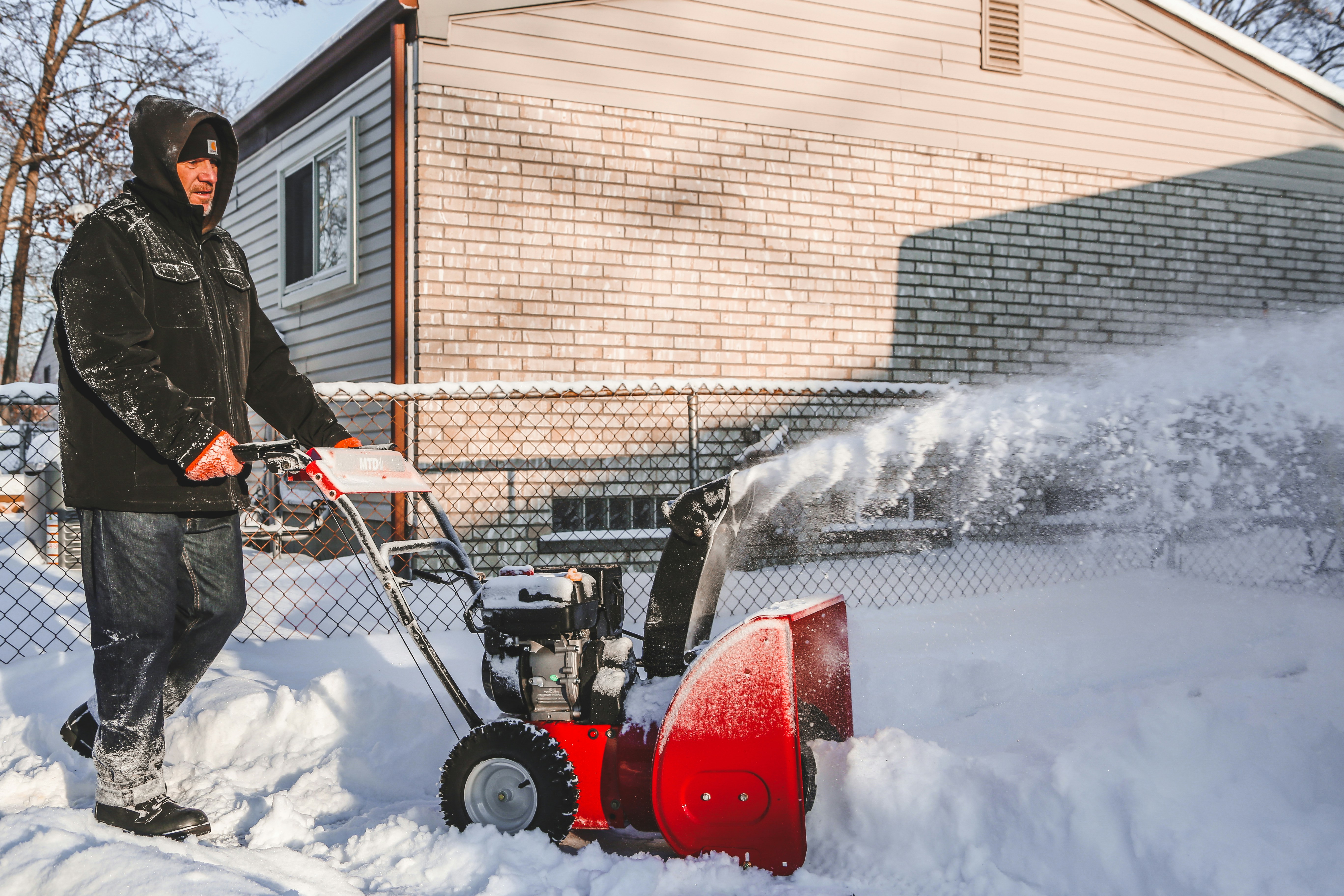 hvordan velge snøfreser: en mann rydder snø med en snøfreser