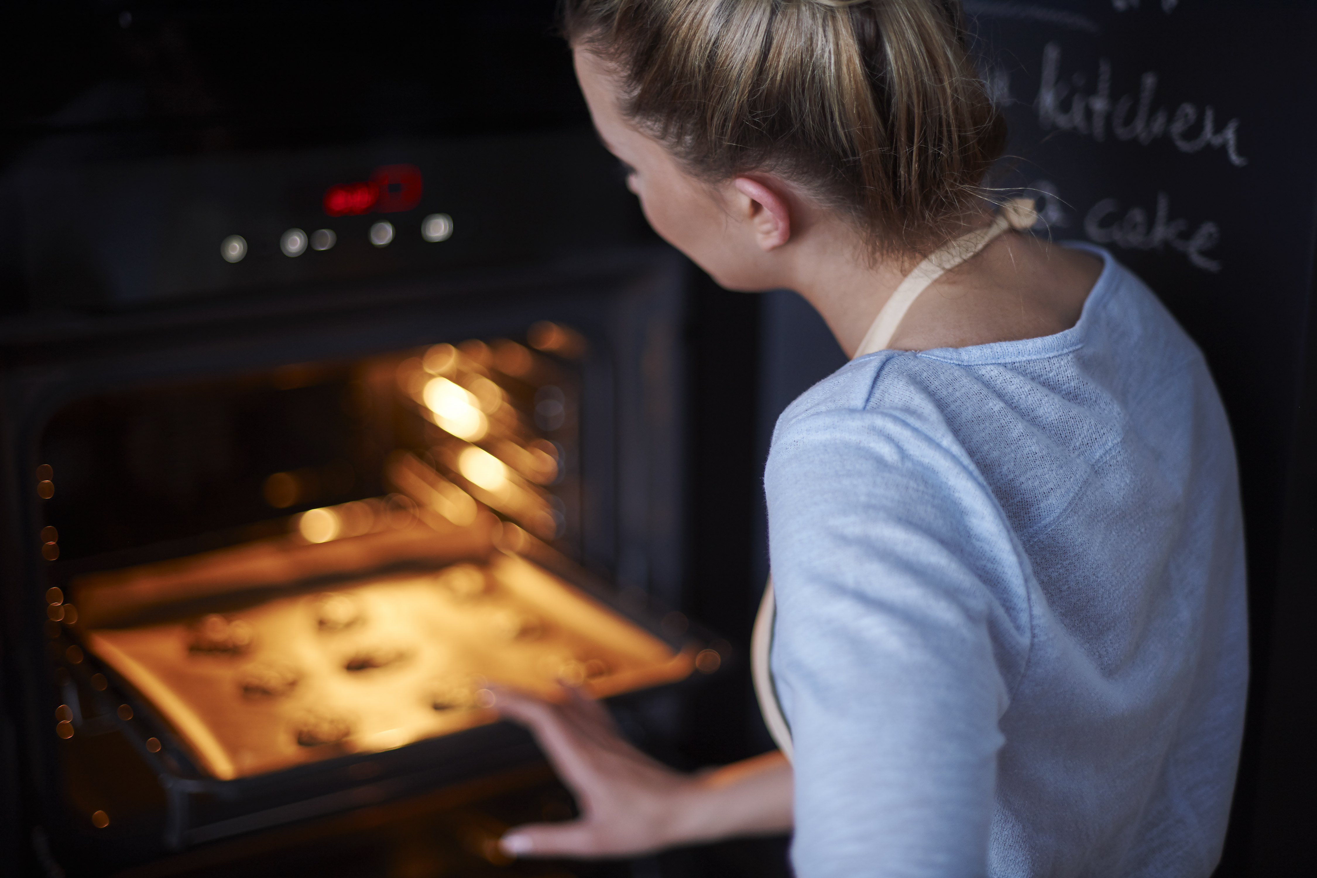 varmluft symbol: en kvinne baker i ovnen